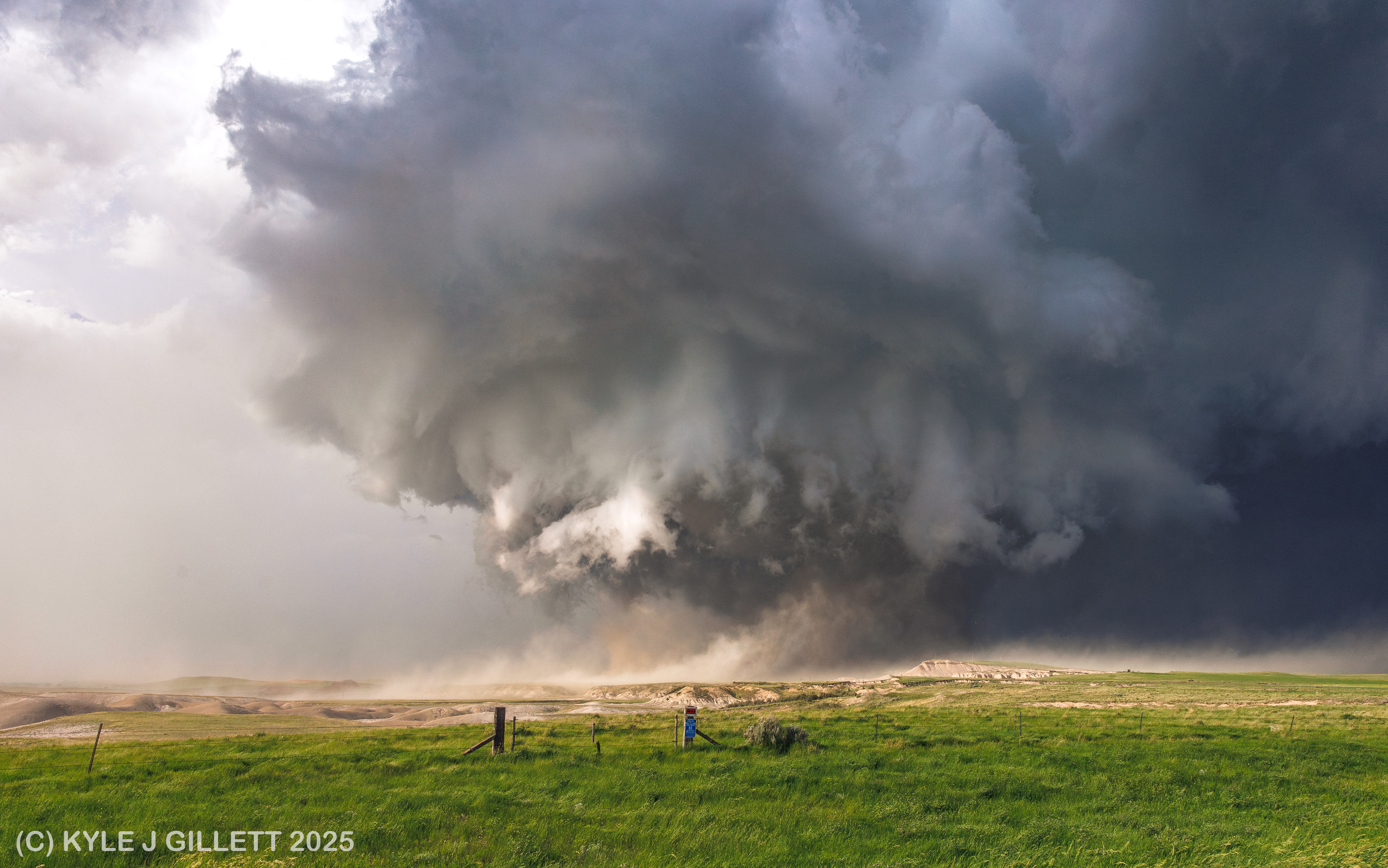 Well-structured low-level mesocyclone with dust marking a new rear-flank downdraft surge.